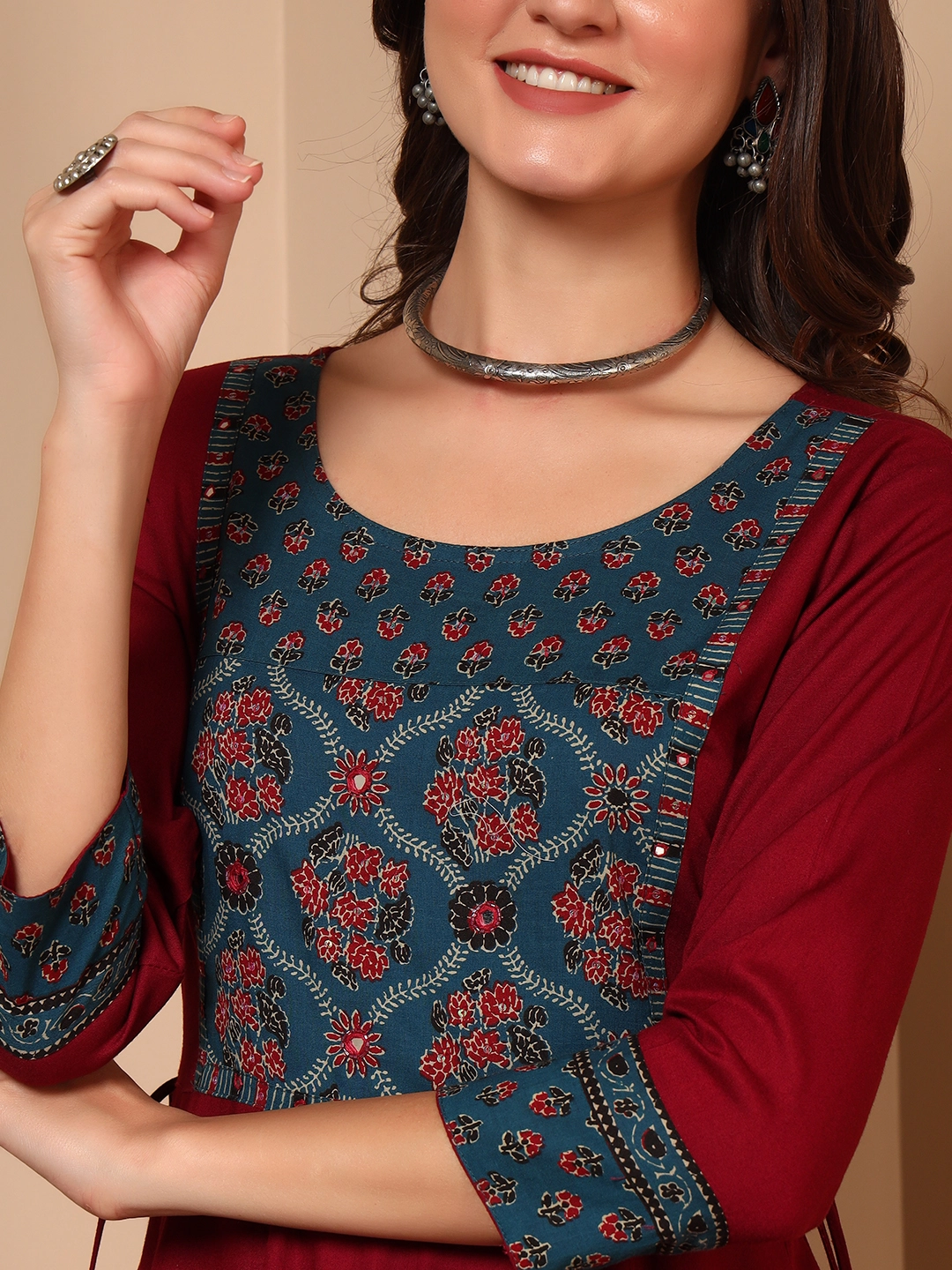 Close-up handwork detailing on red cotton maxi dress neckline